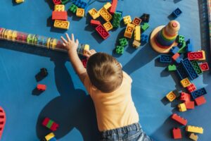 Happy baby playing with toy blocks.